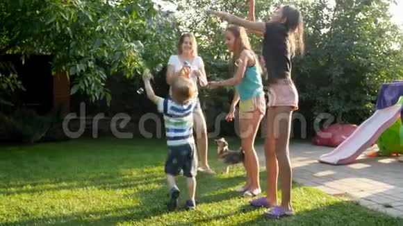 4K慢动作视频快乐家庭与孩子吹肥皂泡在后院花园温暖的晴天视频的预览图