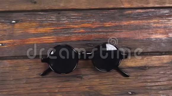 起重机相机向上移动复古太阳镜躺在一个美丽的旧的木制桌子与复制空间视频的预览图