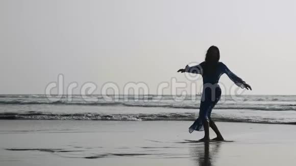 年轻体操女子在沙滩上表演体操元素视频的预览图