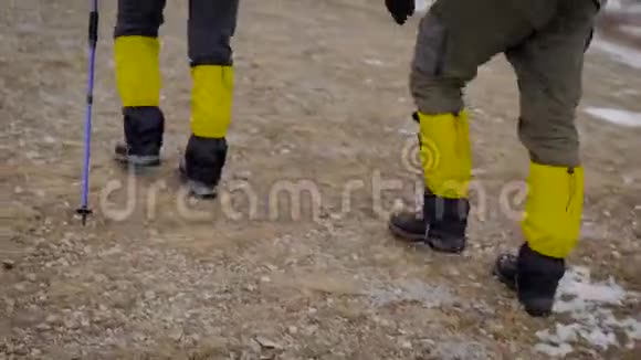 徒步旅行者在上坡时双腿的后视图帮助他们使用滑雪杆视频的预览图