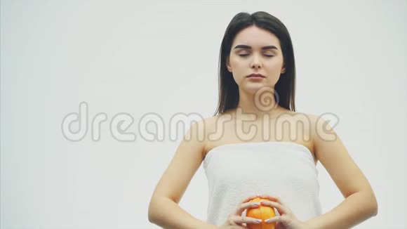 站在白色背景上的年轻漂亮女孩在这期间紧张起来橘子被遮住了眼睛之后视频的预览图