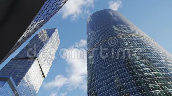 巨大的高大的玻璃摩天大楼戏剧性的太阳和乌云反射时间推移视频的预览图