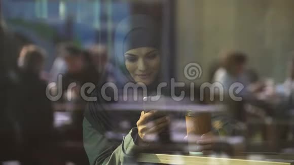 美丽的穆斯林妇女使用移动应用程序进行网上购物预订酒店视频的预览图