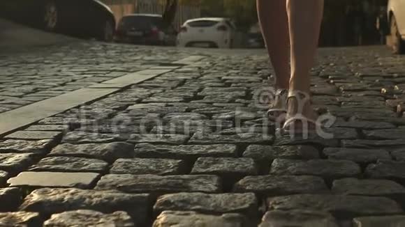 女人的脚从后面人行道上穿过城市的慢动作细节视频的预览图