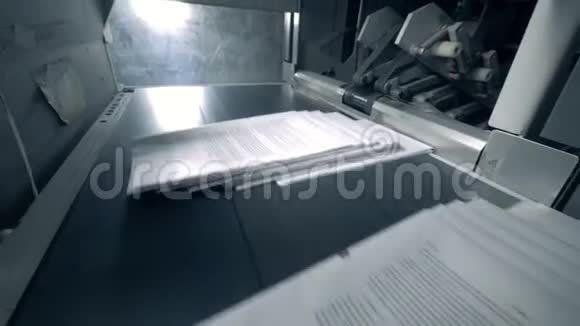 成堆的纸在自动输送机上印刷设施视频的预览图