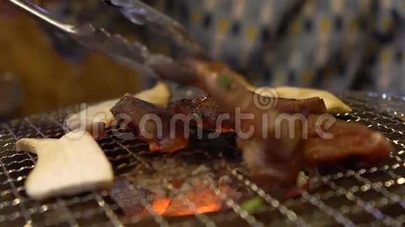 热煤上的慢动作猪肉和牛肉烤架日式烧烤场特色视频的预览图