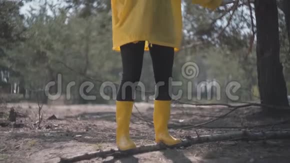 穿黄色橡胶靴的人体和树干上的外套平衡视频的预览图