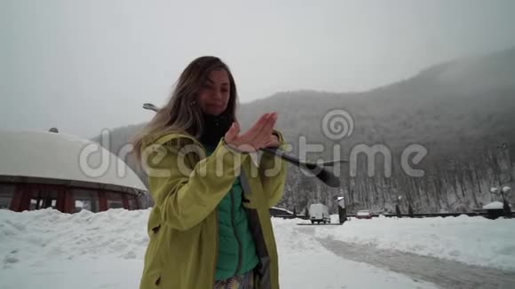 女孩正在准备滑雪年轻的女滑雪者喜欢雪花从天空中飘落雪花落在手上视频的预览图
