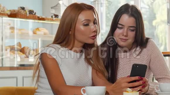 两位女性朋友在咖啡店通过智能手机上网视频的预览图