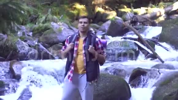 一名男子在森林中与一条山河相望的画像视频的预览图