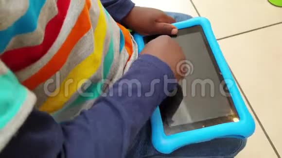 黑人幼儿玩平板电脑并试图打开它幼儿在厨房里拿平板电脑视频的预览图