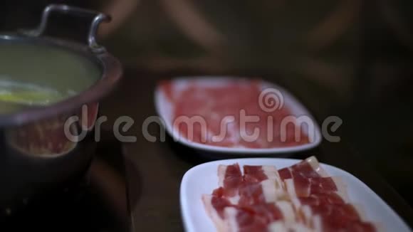 4K中国麻辣火锅汤餐桌上猪肉和牛肉的生肉片视频的预览图