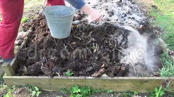 园丁在堆肥堆土中加入木灰肥料视频的预览图