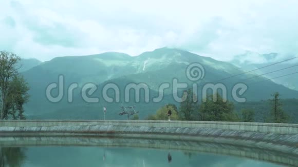 徒步旅行者夫人的小身影和她美丽的倒影在湖面的镜面上与遥远的梦幻相映视频的预览图