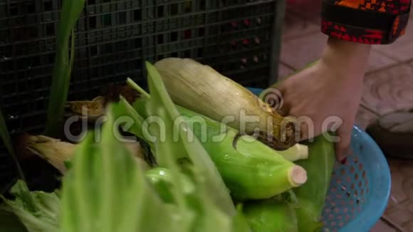 慢镜头亚洲店主手拿玉米在市场上的玉米棒视频的预览图