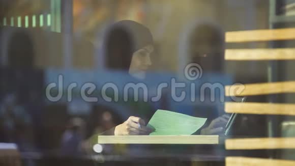 戴头巾的自信女士在咖啡馆工作在合同里查资料会计视频的预览图