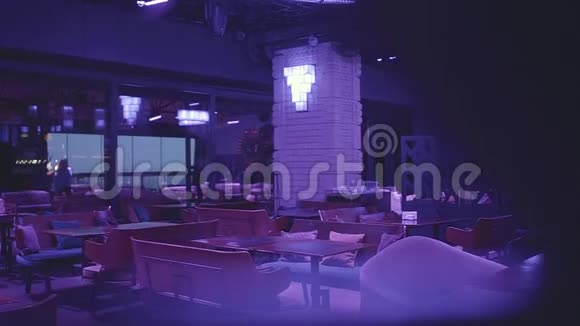 豪华空夜俱乐部在蓝光有许多舒适的扶手椅和桌子等待游客视频的预览图