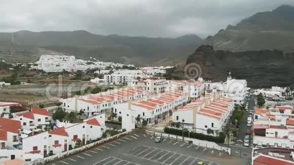 以上雾蒙蒙的山脚下的村庄白色的房子橙色的屋顶西班牙的建筑度假视频的预览图