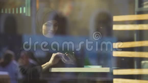 美丽自信的穆斯林女性化妆坐在咖啡馆里打扮视频的预览图