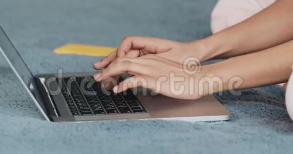 特写女人她的手使用笔记本电脑在床上女孩在家里用笔记本电脑打电话技术概念视频的预览图