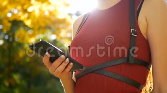 女子公园手讯智能手机秋季视频的预览图