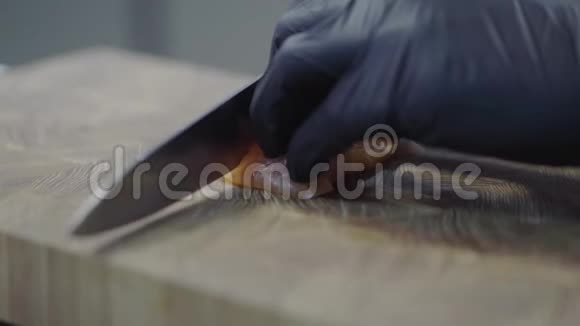 厨师手戴黑色橡胶手套在现代餐厅特写的木板上切三文鱼海洋食物视频的预览图