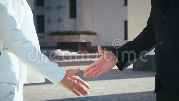 商业人士握手商务办公大楼在户外的商务男性和商务女性之间握手视频的预览图