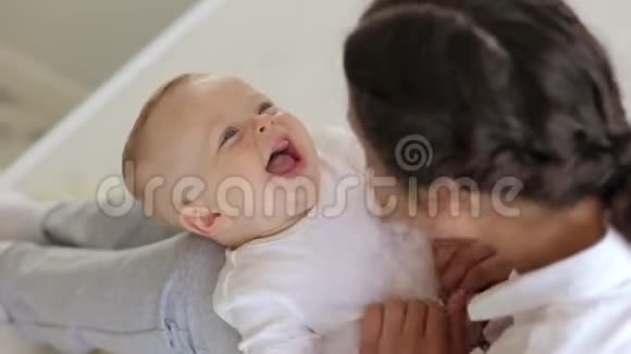 快乐的妈妈在家里和她刚出生的小儿子玩特写镜头视频的预览图