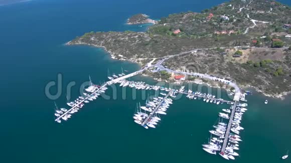 在希腊哈尔基迪基的帕纳亚湾用游艇码头进行绿松石海的空中拍摄由无人驾驶飞机进行圆周运动视频的预览图
