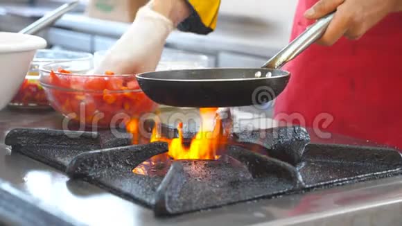 不可识别的厨师在现代餐厅厨房烹饪素食菜肴男厨师拿着热锅扔东西视频的预览图