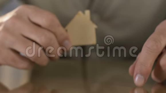 成熟的男人在镜头前拿着木制的房子在临终关怀院失踪了视频的预览图
