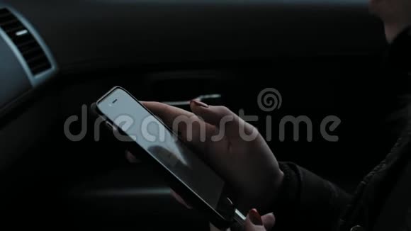 一个女孩坐在车里打电话使用电话视频的预览图