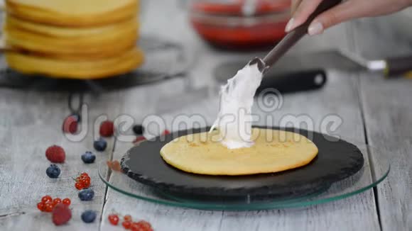 糖果师把奶油涂抹在层蛋糕上用浆果馅做蛋糕的过程视频的预览图