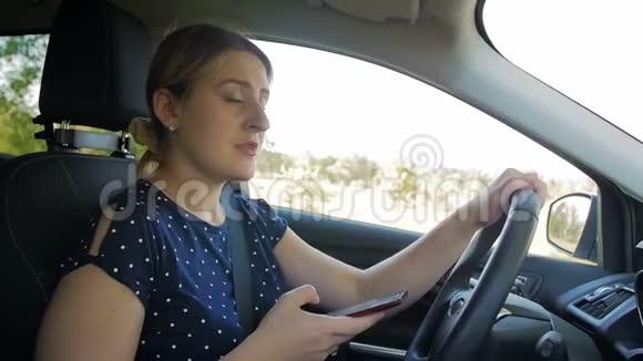 慢动作视频不负责任和粗心的女人在智能手机上键入信息时驾驶汽车请使用视频的预览图