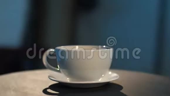相机围绕白色杯子和黑色桌子上的碟子蓝色背景视频的预览图