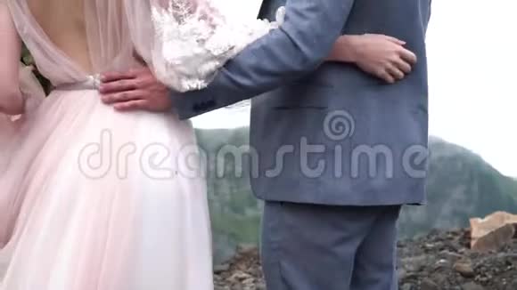 近侧观浪漫感人新婚夫妇温柔地拥抱在一起周围是山峰视频的预览图