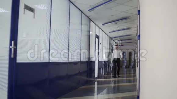 商人走在办公室走廊上视频的预览图