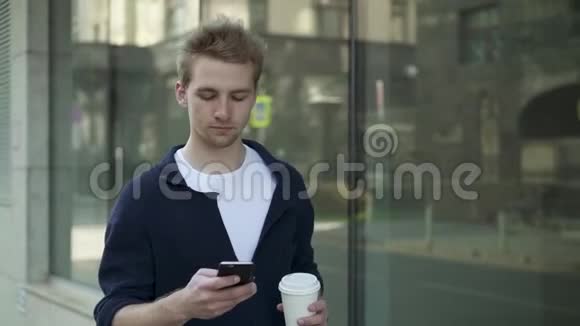 一个严肃的男人在街上喝咖啡上网视频的预览图