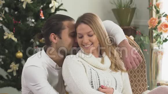 一对幸福夫妇坐在家中圣诞树附近的肖像妻子和丈夫在一起很幸福恋爱关系视频的预览图