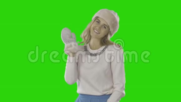 优雅的年轻女子戴着帽子戴着手套微笑着挥手双手按在脸颊上新年视频的预览图