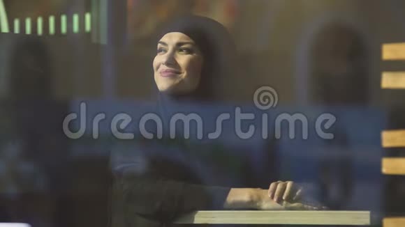 年轻迷人的穆斯林女性在咖啡馆享受阳光没有偏见视频的预览图