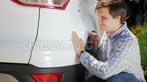 年轻人检查他的新车的慢动作视频男司机用手触摸车辆视频的预览图