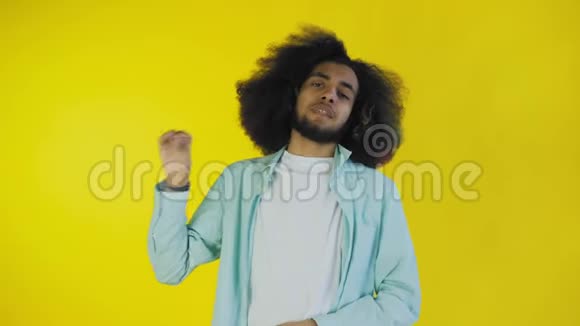 年轻的非裔美国人在黄色背景上表现出沉默或BLABLA手势情感概念视频的预览图