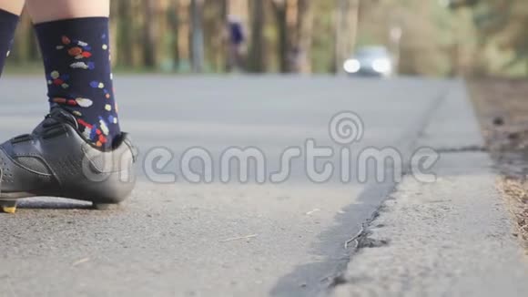 活泼的女孩在训练前收紧黑色和灰色的道路自行车鞋慢动作视频的预览图