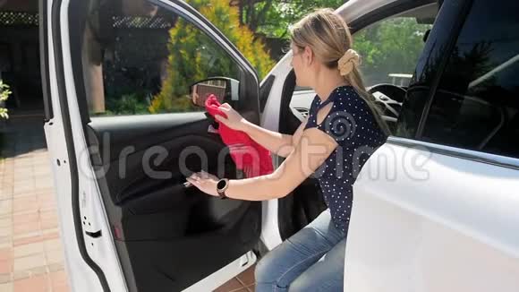 年轻女司机用红色微纤维布清洗她的慢动作视频视频的预览图