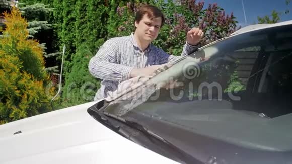 男司机在自家后院擦车窗和车窗的4K镜头照顾私人车辆视频的预览图