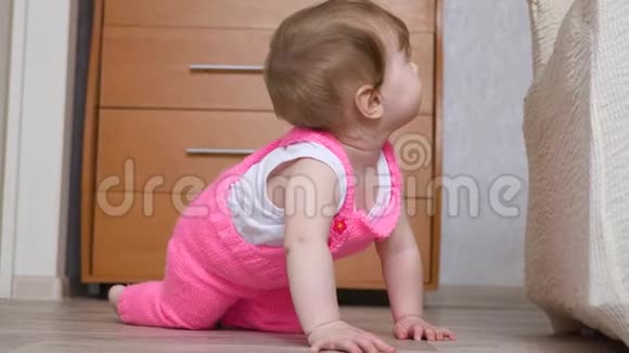 快乐的小宝宝在托儿所地板上爬行特写镜头视频的预览图