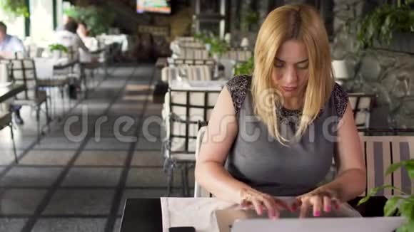 咖啡馆里的女人在笔记本电脑上工作视频的预览图