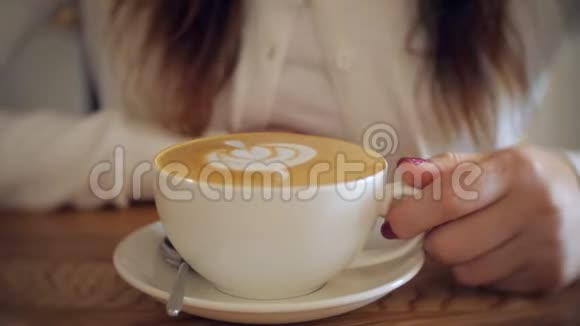 年轻女孩喜欢美味咖啡的香气视频的预览图