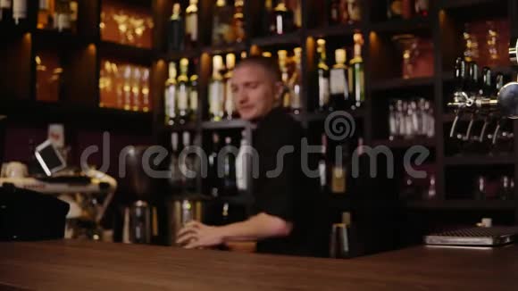 4一个酒吧的酒保把一杯鸡尾酒倒入玻璃杯里视频的预览图